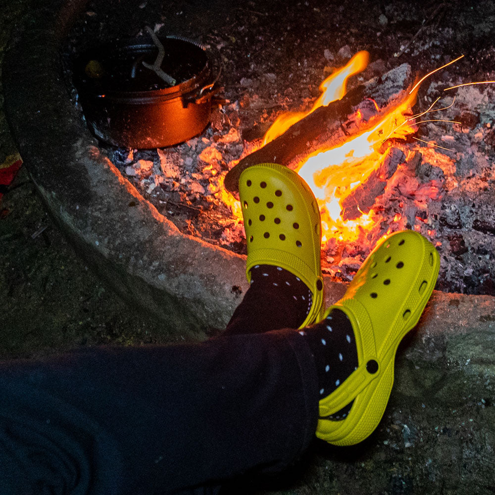 Yellow off-road clogs worn beside a campfire at night.