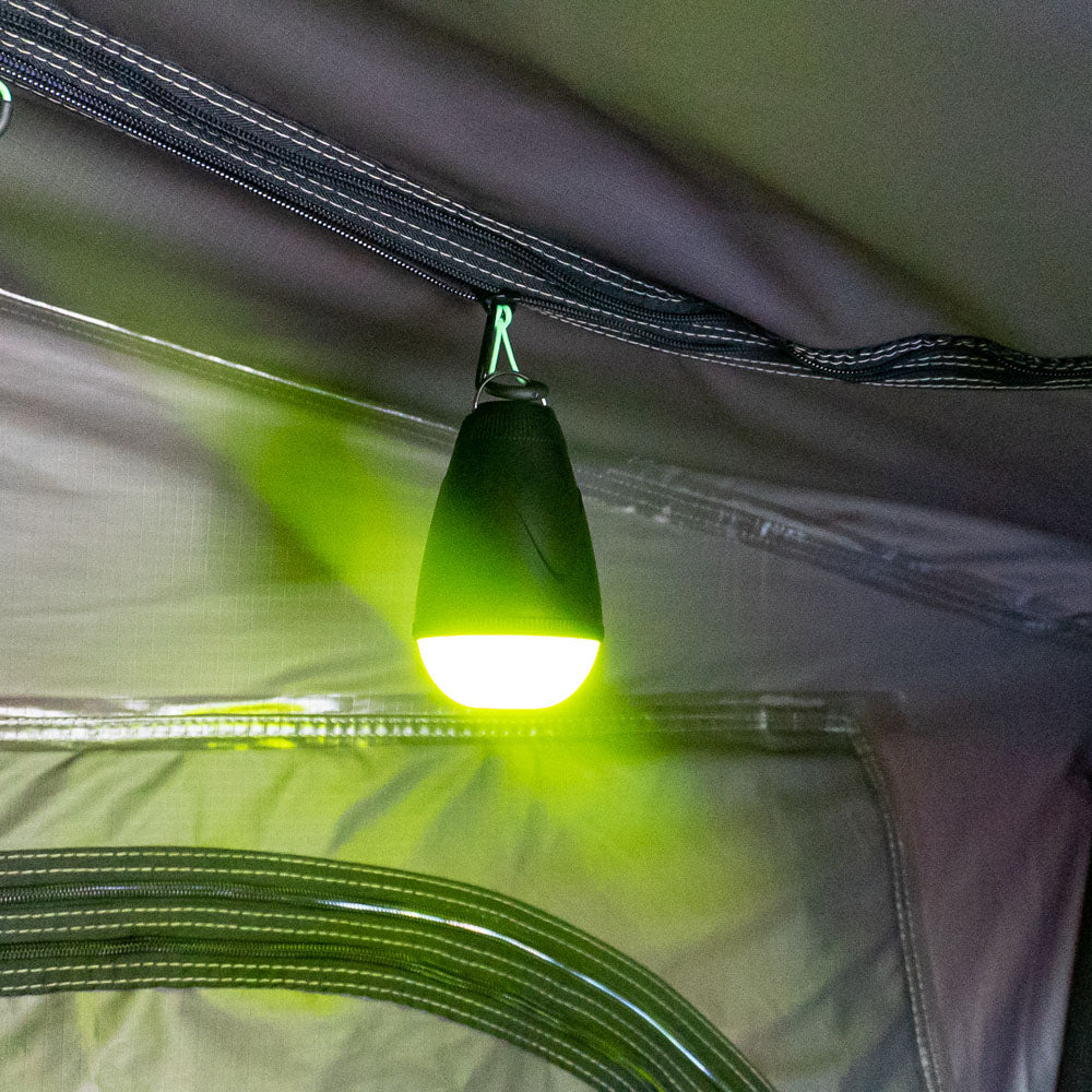 LED camping light with insect repellent glow hanging inside a tent, providing soft yellow ambient lighting
