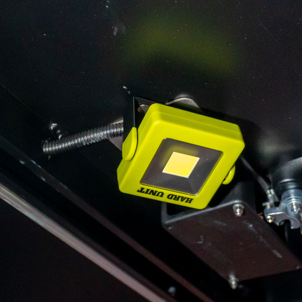 Square LED work light mounted under canopy roof, providing hands-free overhead lighting for camping or 4WD setups.