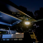 LED camping lantern mounted under canopy lid at night, providing bright overhead lighting for outdoor 4WD setup